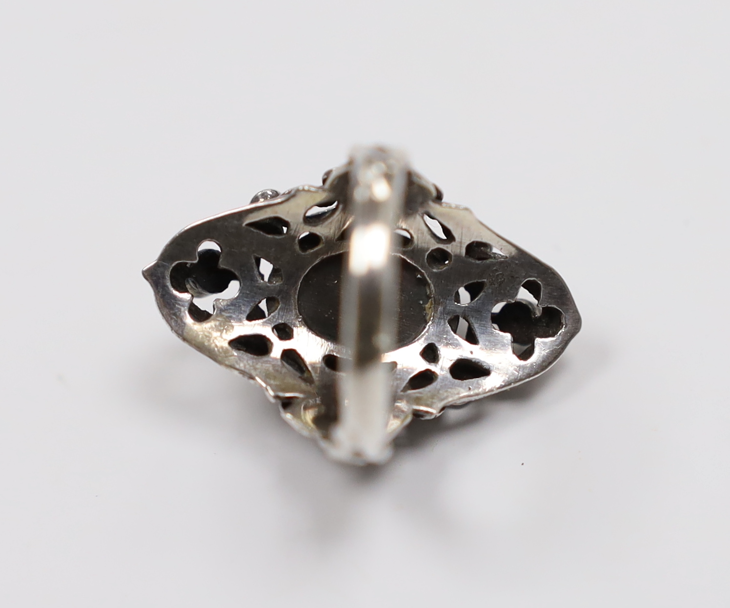 An Arts & Crafts pierced white metal and blue cabochon set dress ring, bordered with seven (ex 8) blue stones, size M.